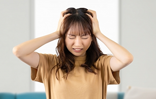 頭皮アートメイクの費用について頭を抱える女性