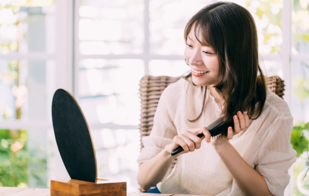つむじ割れを防ぐヘアケアとして髪をブラッシングする女性